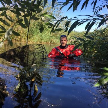 Ben Dittbrenner evaluating a pond leveling device, used to manage beaver dams non-lethally