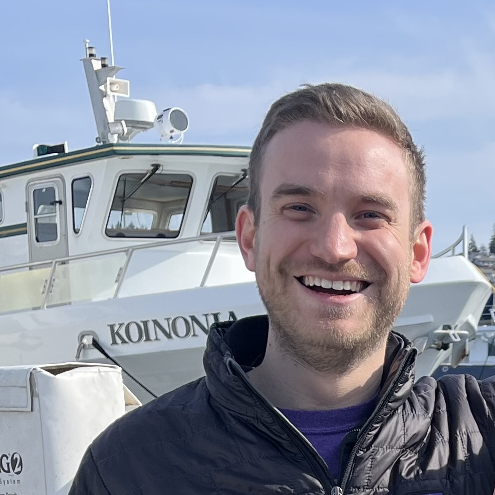 Photo of NW CASC Faculty Fellow Sam Kastner. Sam smiles in front of a boat.