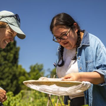 \Student and teacher lean over butterfly net.